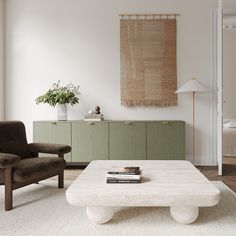 a living room with two chairs and a coffee table in front of a painting on the wall