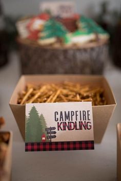 a box filled with fries next to some boxes of other food on a table in front of them