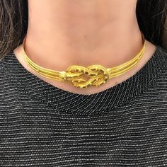 The 22 karat chocker necklace signed by the famous greek jewelry designer Ilias Lalaounis is reminiscent of the Ancient Greek style jewelry. Made in Greece the necklace is skillfully hand executed with extensive mil-grain work. It features the Hercules infinity knot in the center. The Chocker is 14 ½ inches and lays comfortably on the neck, the clasp is concealed as part of the knot. The gross weight is 58.1 grams.