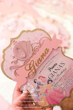 a person holding up a pink and gold princess birthday card with the word grandma on it