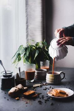 a person pours coffee into two cups