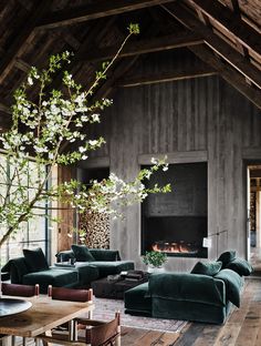 a living room filled with furniture and a fire place next to a wooden floored wall