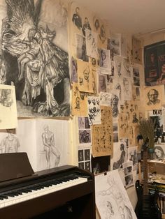 a piano in front of a wall covered with pictures and drawings on it's walls