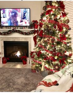 a living room with a christmas tree and television in the corner, decorated for christmas