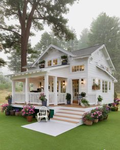 a white house with lots of flowers on the lawn