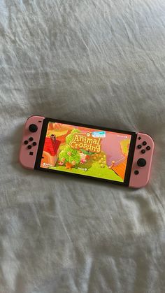 a pink nintendo switch sitting on top of a bed