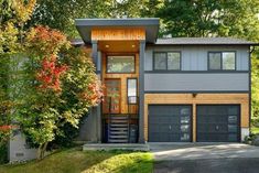 a two story house in the woods with garages and stairs leading to the second floor