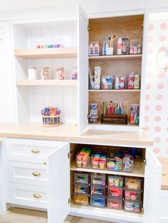 an organized pantry with lots of crafting supplies in the cupboards and shelves on the wall