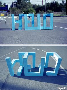 two pictures of blue letters in the middle of a parking lot, one is made out of cardboard