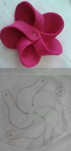 two paper flowers sitting on top of a table next to a piece of paper that has been cut into the shape of an elephant