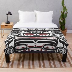 a black and white totema with red eyes on it's face throw blanket