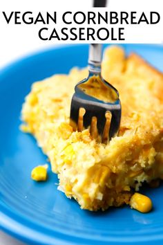 a blue plate topped with cornbread casserole and a fork stuck in it