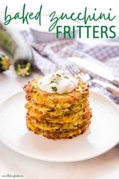 a stack of baked zucchini fritters on a white plate with a fork