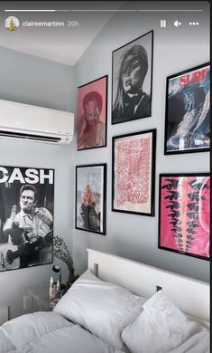 a bedroom with pictures on the wall above the bed