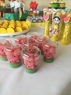 there are many cups with candy in them on the table next to other desserts