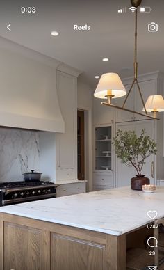 an image of a kitchen setting with lights on the ceiling and counter top in the middle