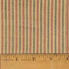 a ruler is measuring the width of a striped fabric with red, green and blue stripes