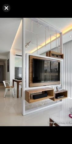 a living room filled with furniture and a flat screen tv on top of a wooden shelf