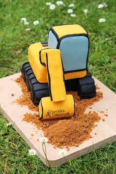 a cake made to look like a construction vehicle on top of some brown dirt and grass