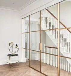 a white room with glass walls and stairs