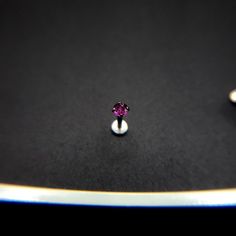 a single pink diamond sitting on top of a table