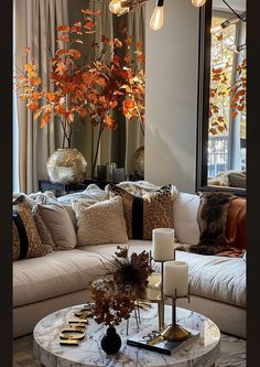 a living room filled with furniture and a large mirror over the couches that has candles on top of it