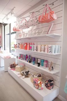 there are many bags and purses on the shelves in this store that is filled with items