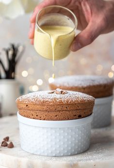 a person is pouring something into a cake