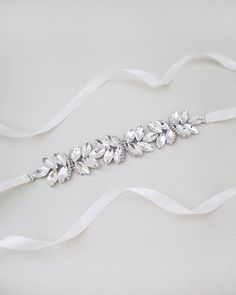 "Ethereally entangled series of butterfly rhinestones attached on bridal white double-faced satin ribbon. Creates sophisticated and romantic finishing touch to your bridal gown, bridesmaids and flower girls. This embellished sash adds a perfect amount of sparkle to create your statement look. DETAIL: Adult Size 108\" Kids Size 78\" Applique size: 7.5\" length, 1.25\" wide HANDMADE IN USA IMPORTED MATERIALS - We DO NOT offer refunds.  Selected items are eligible for EXCHANGE ONLY within 14 days of delivery date. All accessories are FINAL SALE.  - We are not responsible for lost or stolen items during transit. Additional insurance is available upon request. - Stay updated with latest news or promotion as we grow and follow us on the following outlets: Instagram:  http://instagram.com/shop.ka Elegant Bridal Belt With Satin Bow For Bridesmaid, Elegant Bridal Belt With Satin Bow For Wedding, Silver Crystal-embellished Bridesmaid Sash, White Satin Bridal Accessories For Formal Occasion, Silver Bridesmaid Sashes Bridal Accessories, Elegant Ribbon Bridal Belt For Wedding, Satin Bridal Belt With Ribbon For Wedding, Elegant White Bridal Belt With Satin Bow, Elegant White Bridal Belt With Ribbon