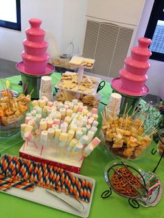 a table topped with lots of candy and candies on top of green cloth covered tables