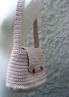 a crocheted handbag hanging on a white mannequin's head