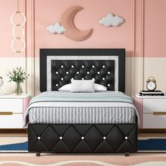 a bedroom with pink walls and black leather headboard, white bedding and nightstands