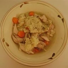 a bowl filled with meat and vegetables on top of a white tablecloth covered table