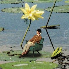 a man is sitting on a chair with a flower in his lap and talking on the phone