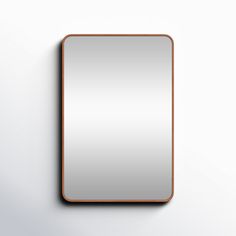 a square mirror mounted on the wall with a wooden frame and metal trim around it