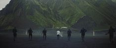 several people are walking in front of a mountain