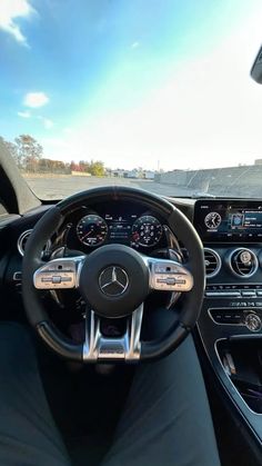 the interior of a mercedes c - class coupe with its steering wheel and dash lights