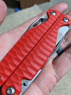 a red pocket knife in someone's hand