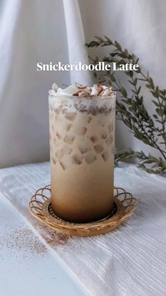 an iced drink sitting on top of a table next to a sprig of leaves