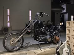 a motorcycle is parked on the side of the road in front of a building at night