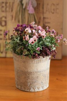 a potted plant sitting on top of a wooden table next to a vase filled with flowers