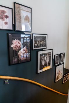 there are many pictures hanging on the wall next to each other and one has a wooden handrail