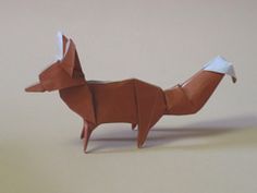 a brown origami fox standing on top of a table