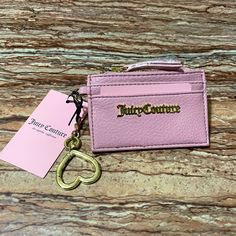 a pink card case with a keychain attached to it