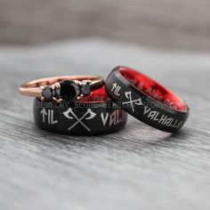 two black and red wedding rings with crosses on the sides, one has a diamond in it