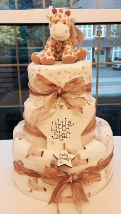 a three tiered cake with a stuffed giraffe on it's top