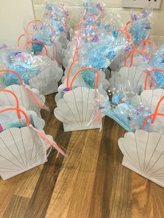 there are many small white parasols on the wooden floor with plastic bags around them