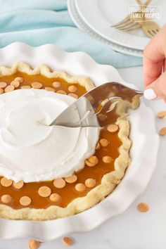 a person cutting into a pie with a knife