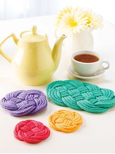 crocheted coasters and tea pot on a table