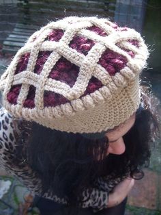 a close up of a person wearing a knitted hat with an interlocked design